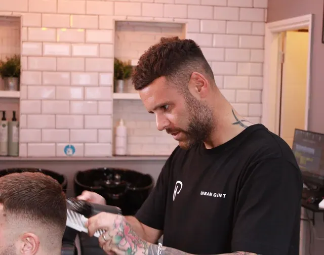A barber clipper-cutting at the station by the basins